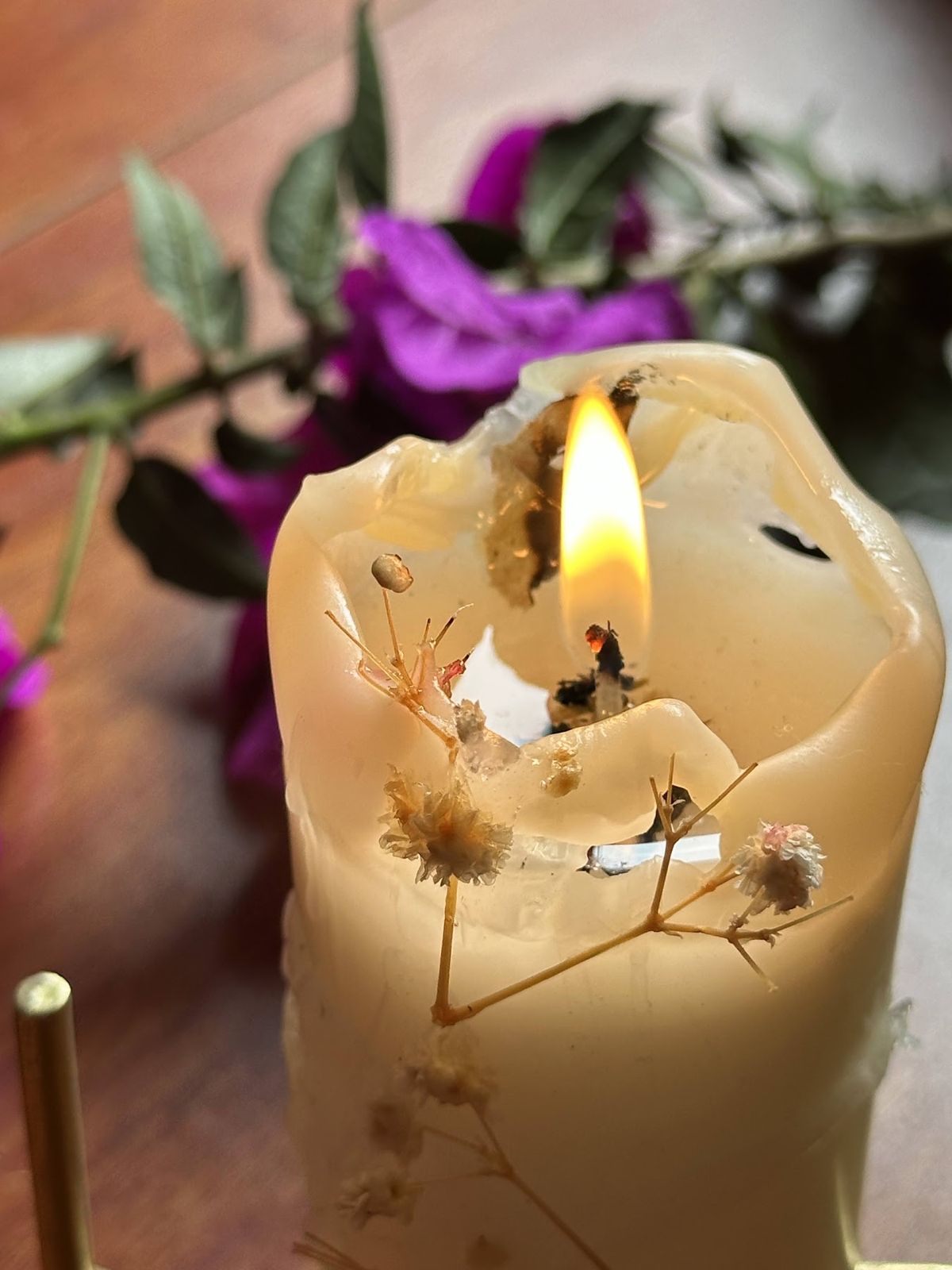Vela artesanal encendida con flores secas